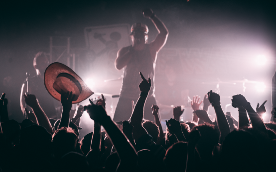 Imagen ilustrativa de la atmósfera de un concierto de indie-pop con escenario iluminado y público
