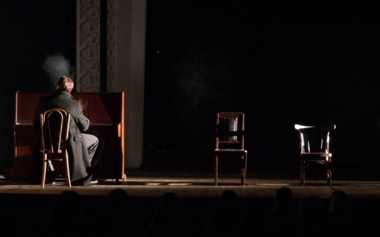 Interior de una sala de conciertos histórica con escenario y piano