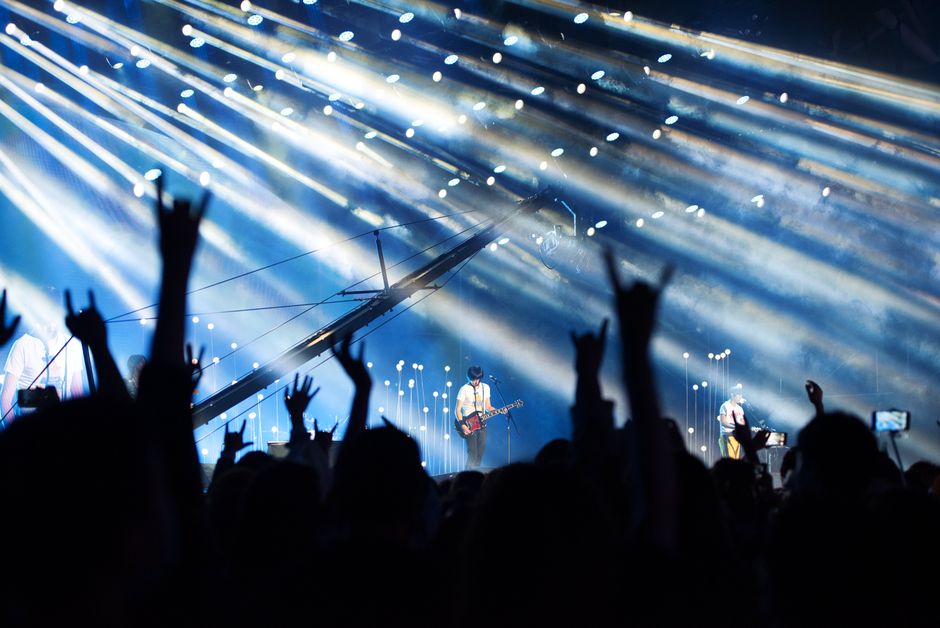 Atmósfera de concierto de metal con iluminación dramática y público entregado