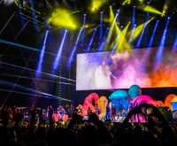 Escenario de festival musical con luces y público, atmósfera de concierto en vivo