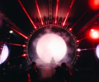 Escenario de concierto con luces intensas y atmósfera electrónica