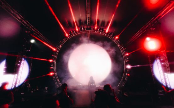 Escenario de concierto con luces intensas y atmósfera electrónica