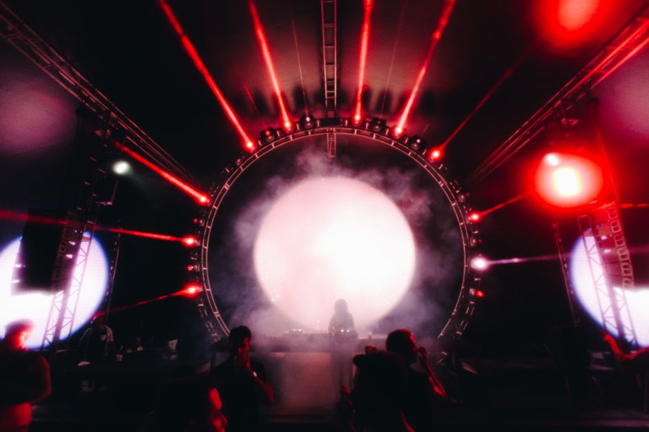 Escenario de concierto con luces intensas y atmósfera electrónica
