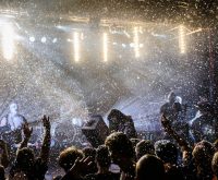 Concierto de pop español en directo con iluminación escénica y ambiente de estadio
