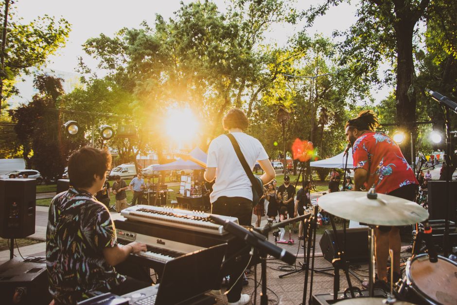 Escenario principal de festival de música al atardecer con luces de producción