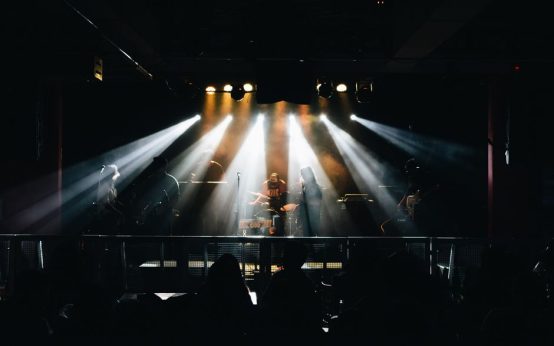 Escenario de concierto de rock con baterías y luces brillantes