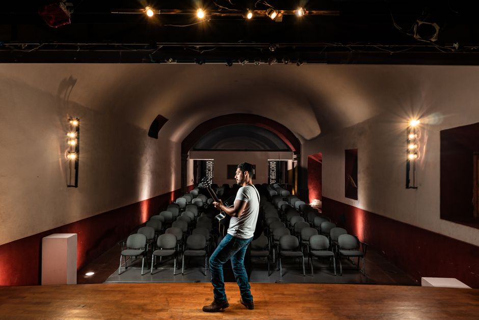 Escenario de concierto vacío con iluminación profesional, atmósfera de rock clásico