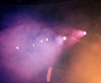 Escenario de concierto con luces coloridas evocando la atmósfera del funk y disco