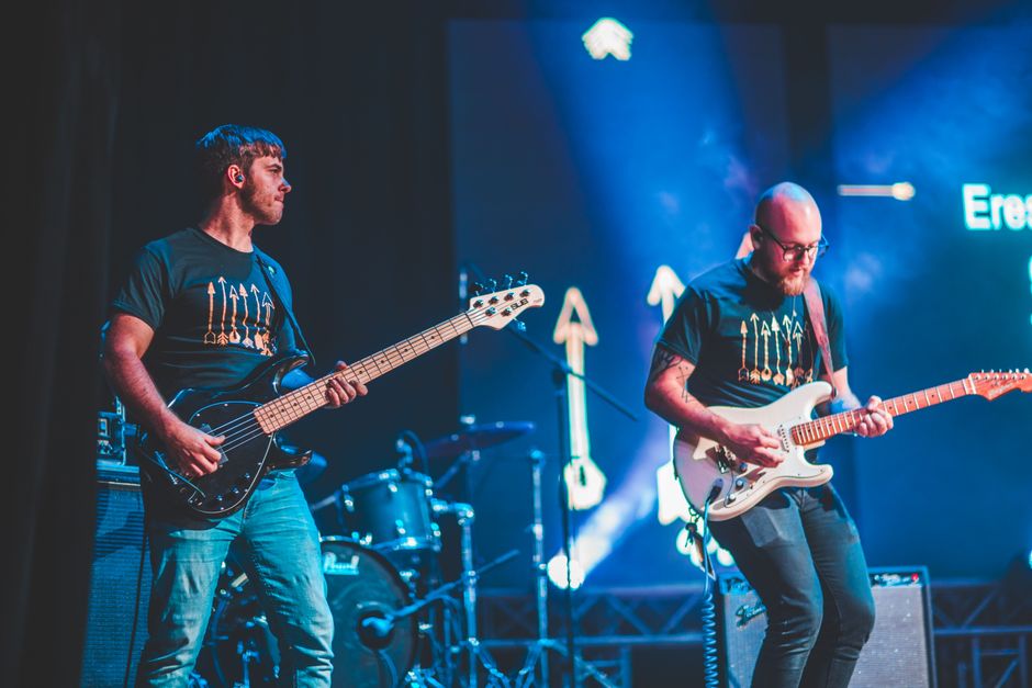 Escenario de concierto indie con focos y ambiente intimista