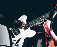 Guitarrista de rock en directo sobre el escenario, atmósfera clásica del rock británico de los 80
