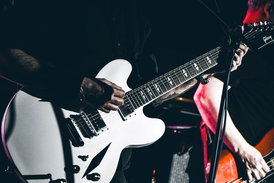 Guitarrista de rock en directo sobre el escenario, atmósfera clásica del rock británico de los 80