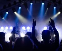 Atmósfera de concierto de rock indie con luces de escenario y público