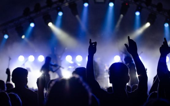 Atmósfera de concierto de rock indie con luces de escenario y público