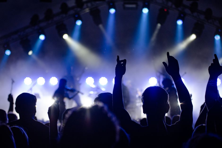 Atmósfera de concierto de rock indie con luces de escenario y público
