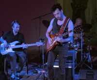 Escenario de festival indie con luces y ambiente nocturno al aire libre