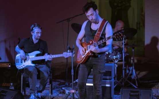 Escenario de festival indie con luces y ambiente nocturno al aire libre
