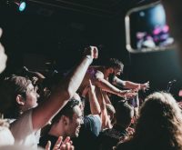 Ambiente de concierto indie rock con escenario iluminado y público