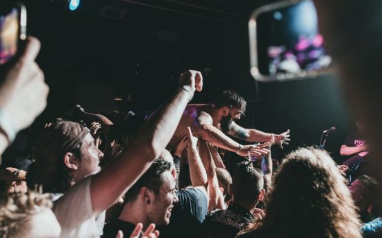 Ambiente de concierto indie rock con escenario iluminado y público