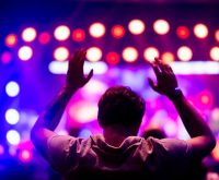 Ambiente de concierto pop en vivo con luces escénicas y público emocionado