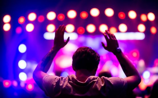 Ambiente de concierto pop en vivo con luces escénicas y público emocionado