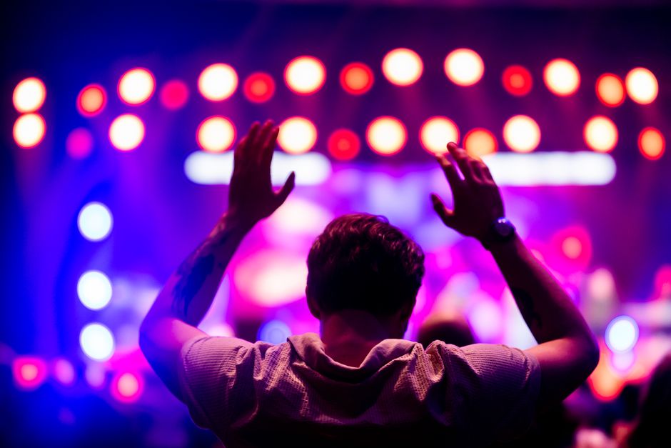 Ambiente de concierto pop en vivo con luces escénicas y público emocionado