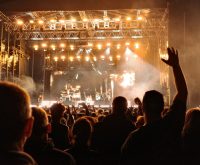 Ambiente de festival de música al aire libre con escenario iluminado