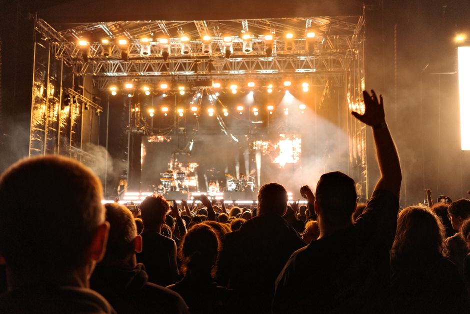 Ambiente de festival de música al aire libre con escenario iluminado