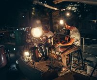 Escenario de concierto en sala de música en vivo con iluminación cálida y atmósfera intimista