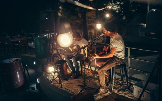 Escenario de concierto en sala de música en vivo con iluminación cálida y atmósfera intimista