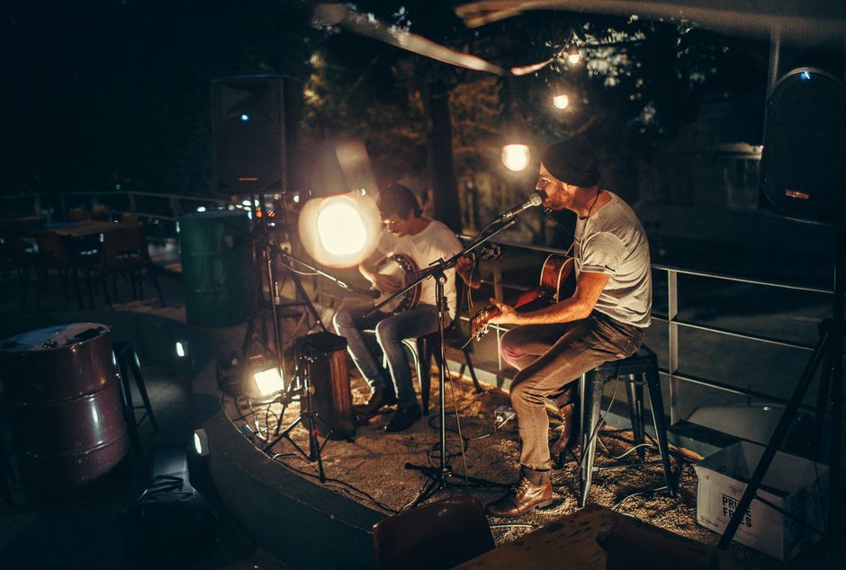 Escenario de concierto en sala de música en vivo con iluminación cálida y atmósfera intimista