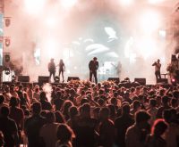 Escenario de festival de música independiente al aire libre con público