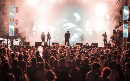 Escenario de festival de música independiente al aire libre con público