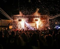 Escenario de concierto iluminado con público asistente