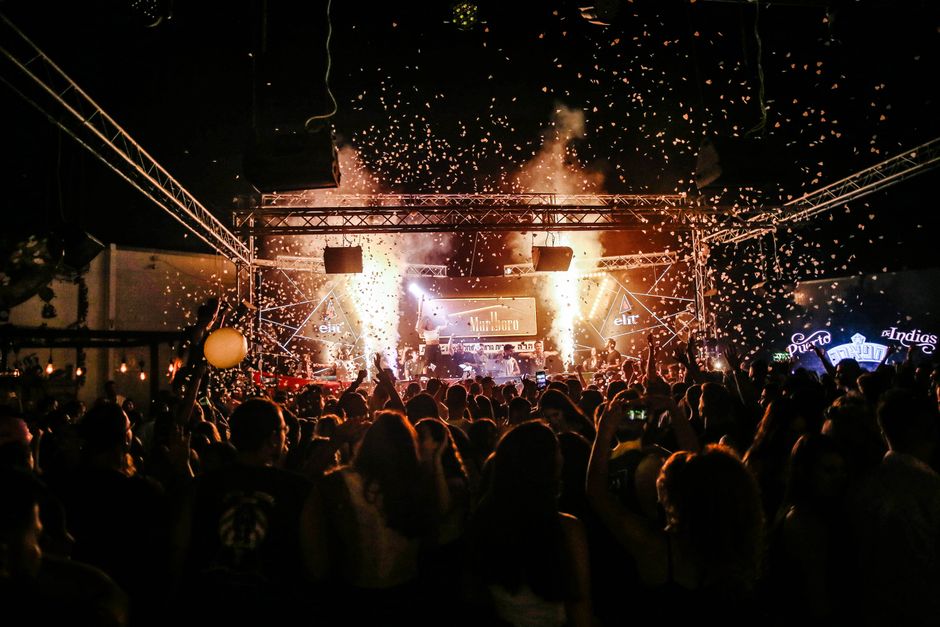 Escenario de concierto iluminado con público asistente