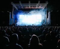 Atmósfera de concierto multitudinario con luces de escenario