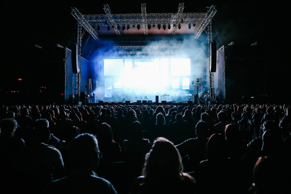Atmósfera de concierto multitudinario con luces de escenario