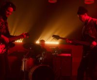 Actuación de rock indie en directo con luces de escenario y ambiente nocturno