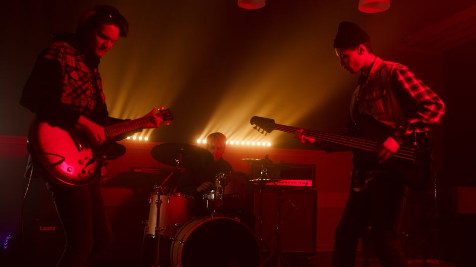 Actuación de rock indie en directo con luces de escenario y ambiente nocturno