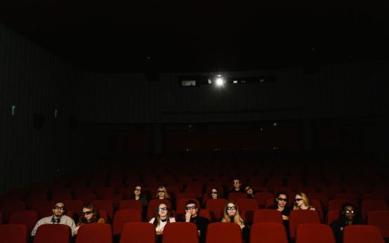 Imagen ilustrativa. Interior de una sala de cine con pantalla iluminada