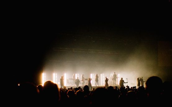 Escenario de concierto de rock con luces intensas y público entusiasta