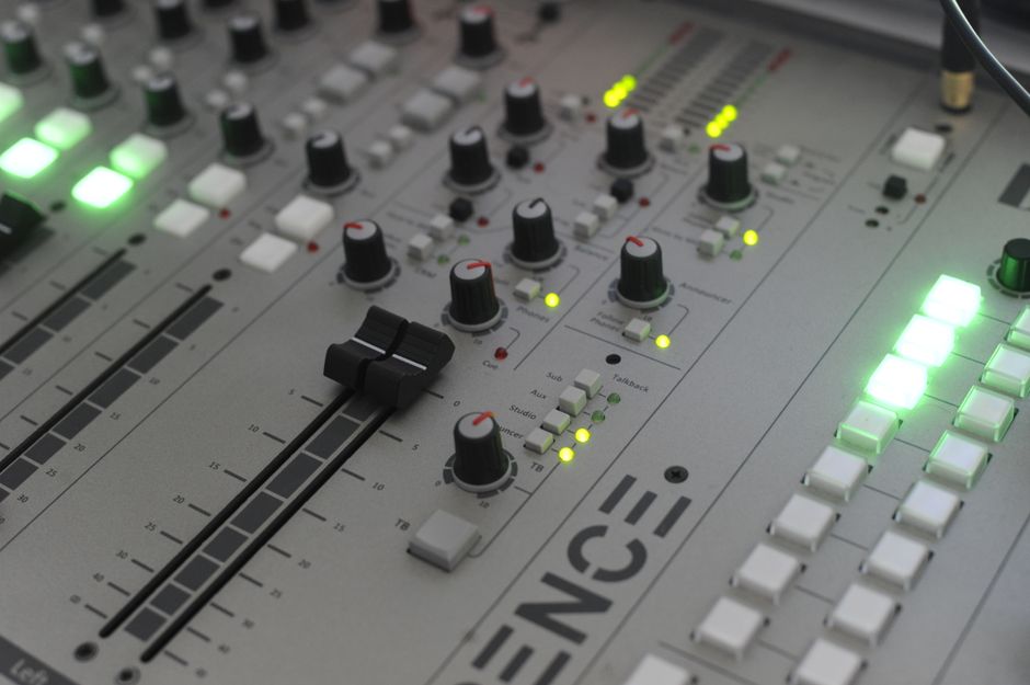 Atmósfera de estudio de grabación profesional con consola de mezclas e iluminación cálida