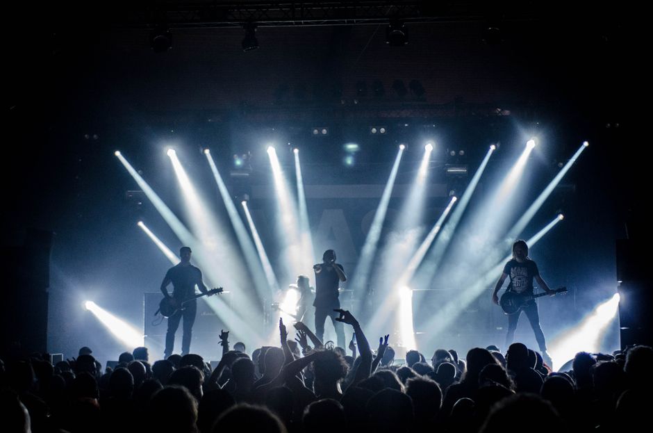 Escenario de concierto post-rock con iluminación atmosférica y equipamiento de guitarra