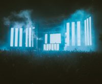 Escenario de concierto con iluminación nocturna y público
