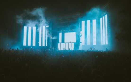 Escenario de concierto con iluminación nocturna y público