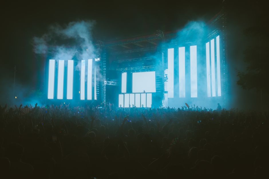 Escenario de concierto con iluminación nocturna y público