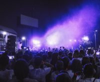 Escenario de festival de música al aire libre con luces y ambiente nocturno