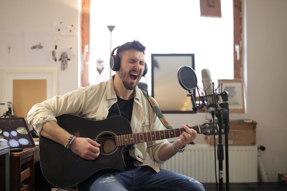 Estudio de grabación acústico con guitarra y micrófono preparados para sesión