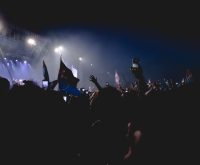 Escenario de gran concierto con iluminación nocturna y público