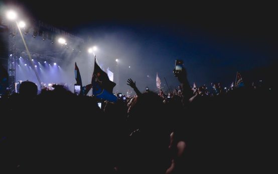 Escenario de gran concierto con iluminación nocturna y público