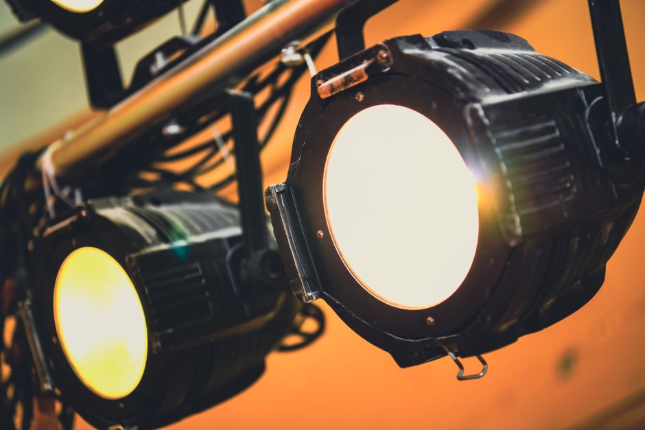 Atmósfera de concierto con luces de escenario y equipo fotográfico
